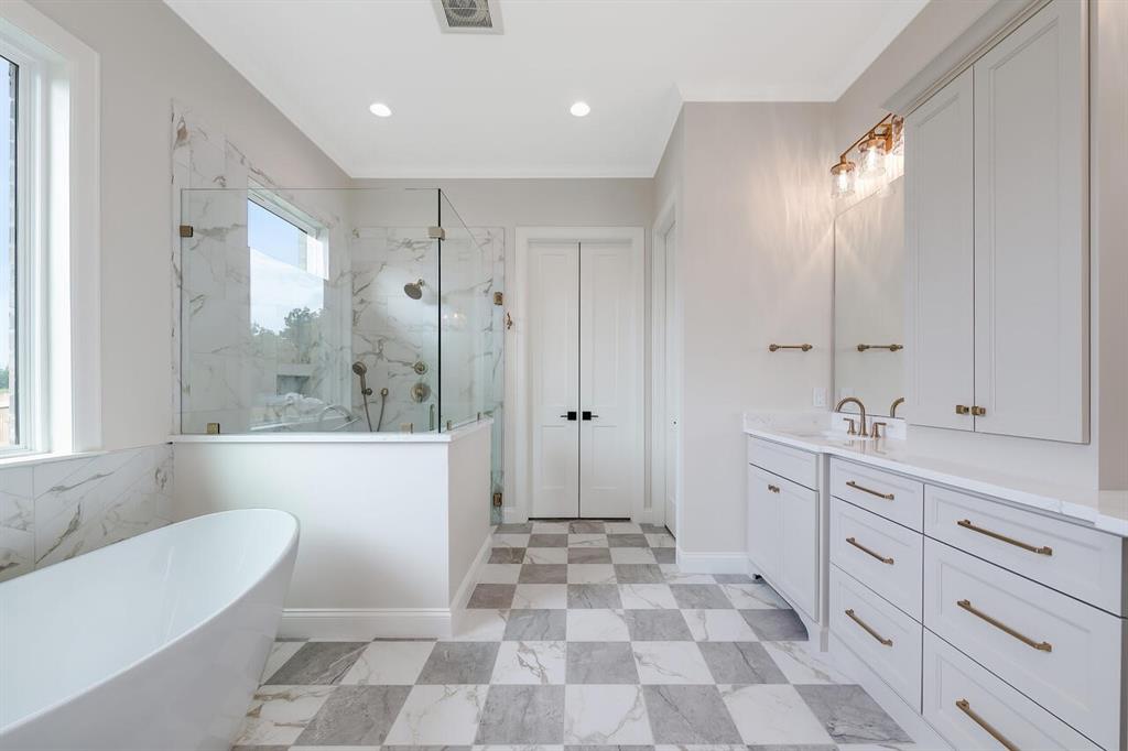 8005 Bee Cave Road China Spring, TX 76633 - Photo 26 of 40 a spacious bathroom with a double vanity sink a mirror and a bathtub