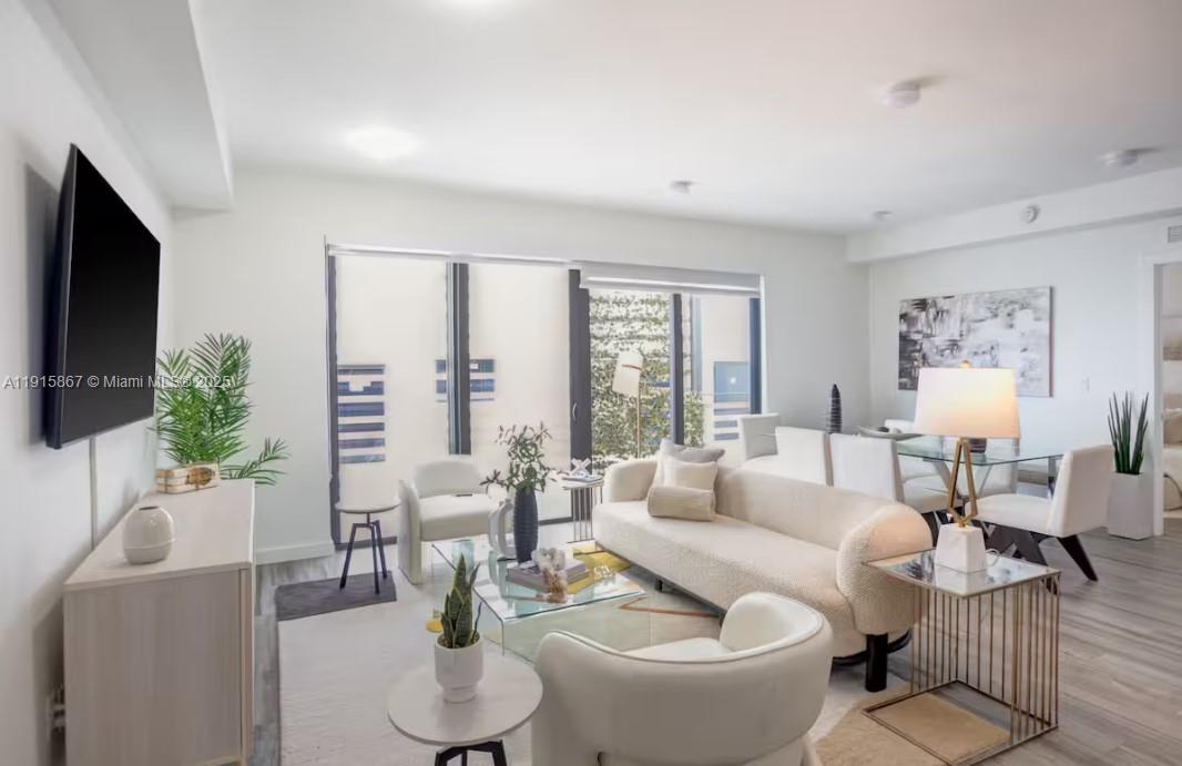 2955 Bird Avenue, Unit PHA Miami, FL 33133 - Photo 1 of 24 a living room with furniture a flat screen tv and a large window