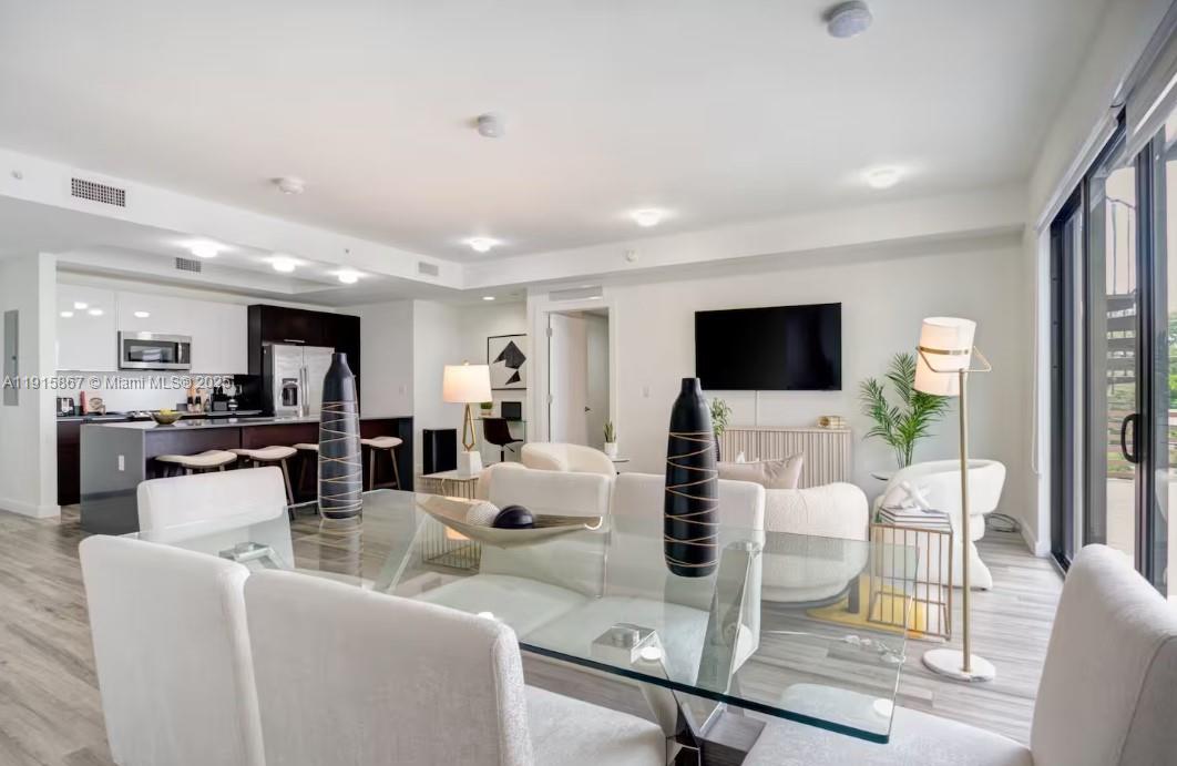 2955 Bird Avenue, Unit PHA Miami, FL 33133 - Photo 4 of 24 a living room with furniture a flat screen tv and a view of kitchen