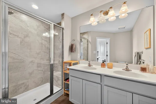 a bathroom with a double vanity sink mirror and shower