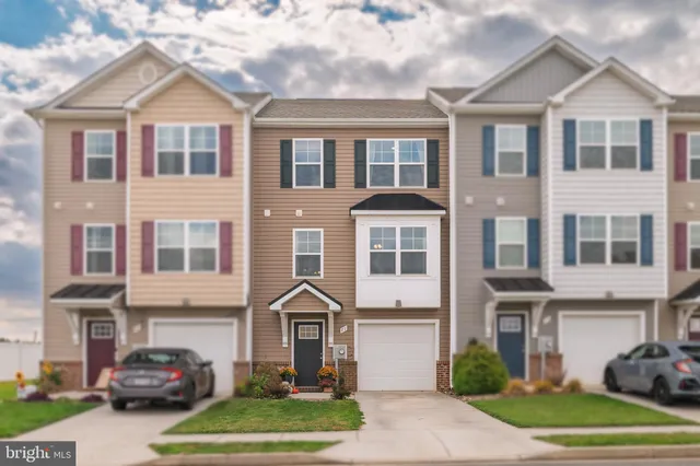 a front view of a residential apartment building with a yard