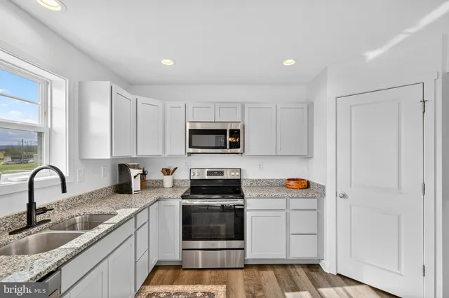 a kitchen with stainless steel appliances granite countertop a sink and cabinets