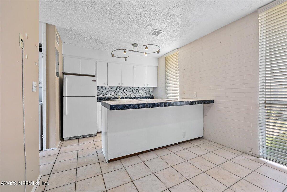 901 Ocean Boulevard, Unit 64 Atlantic Beach, FL 32233 - Photo 10 of 26 a kitchen with white cabinets and white appliances