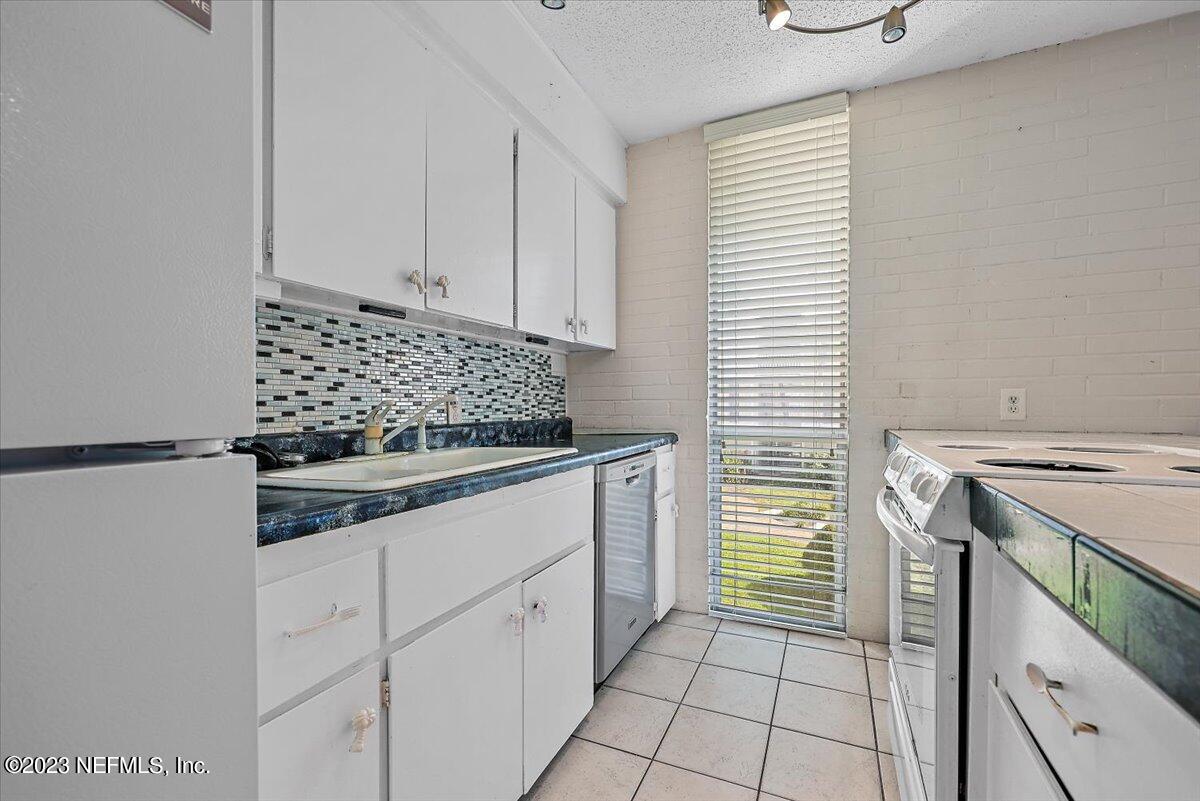 901 Ocean Boulevard, Unit 64 Atlantic Beach, FL 32233 - Photo 11 of 26 a kitchen with appliances cabinets and utility