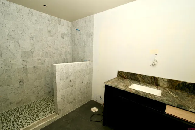 a bathroom with a granite countertop sink and a mirror
