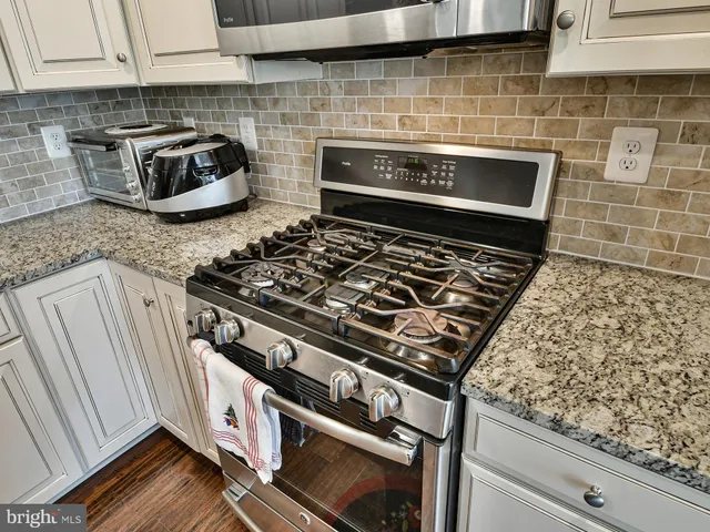 a stove top oven sitting inside of a kitchen