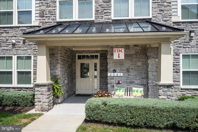 a front view of a building with a garden and plants