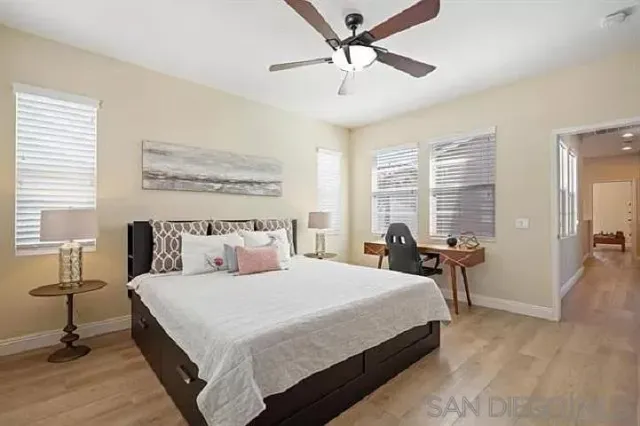 a bedroom with a large bed and a chandelier fan