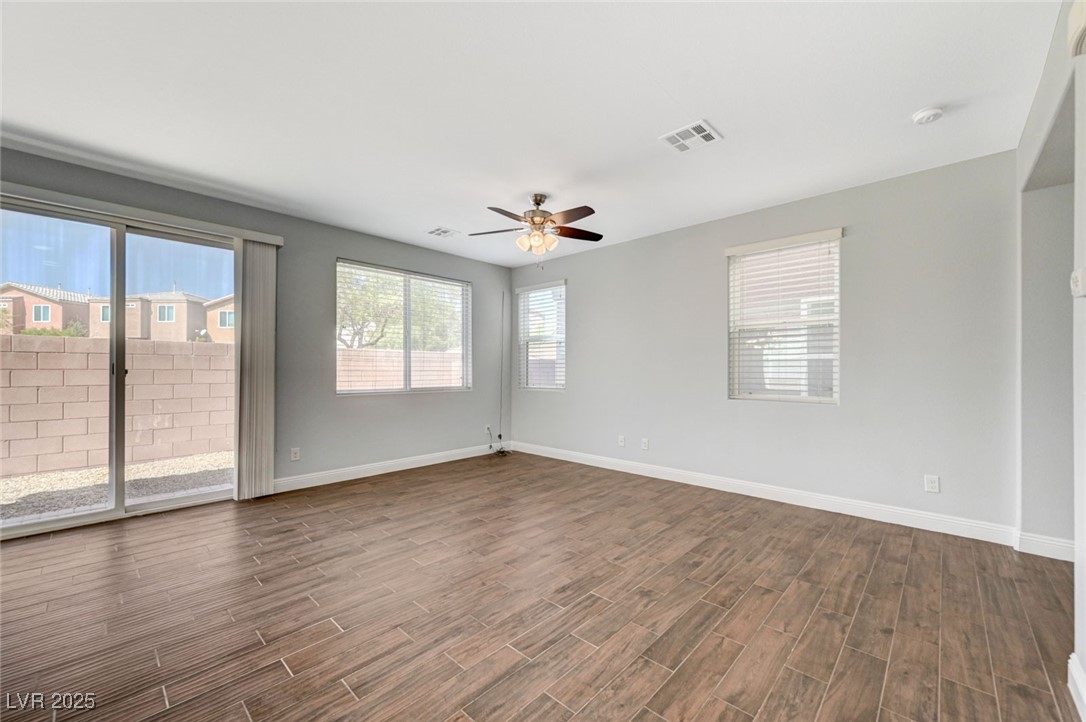 5377 Panaca Spring Street Las Vegas, NV 89122 - Photo 12 of 59 Empty room featuring dark wood-type flooring and a ceiling fan