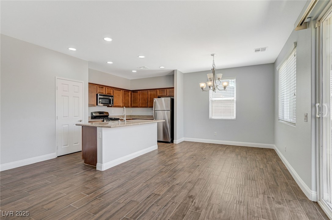 5377 Panaca Spring Street Las Vegas, NV 89122 - Photo 13 of 59 Kitchen featuring decorative light fixtures, appliances with stainless steel finishes, a kitchen island with sink, a chandelier, and recessed lighting