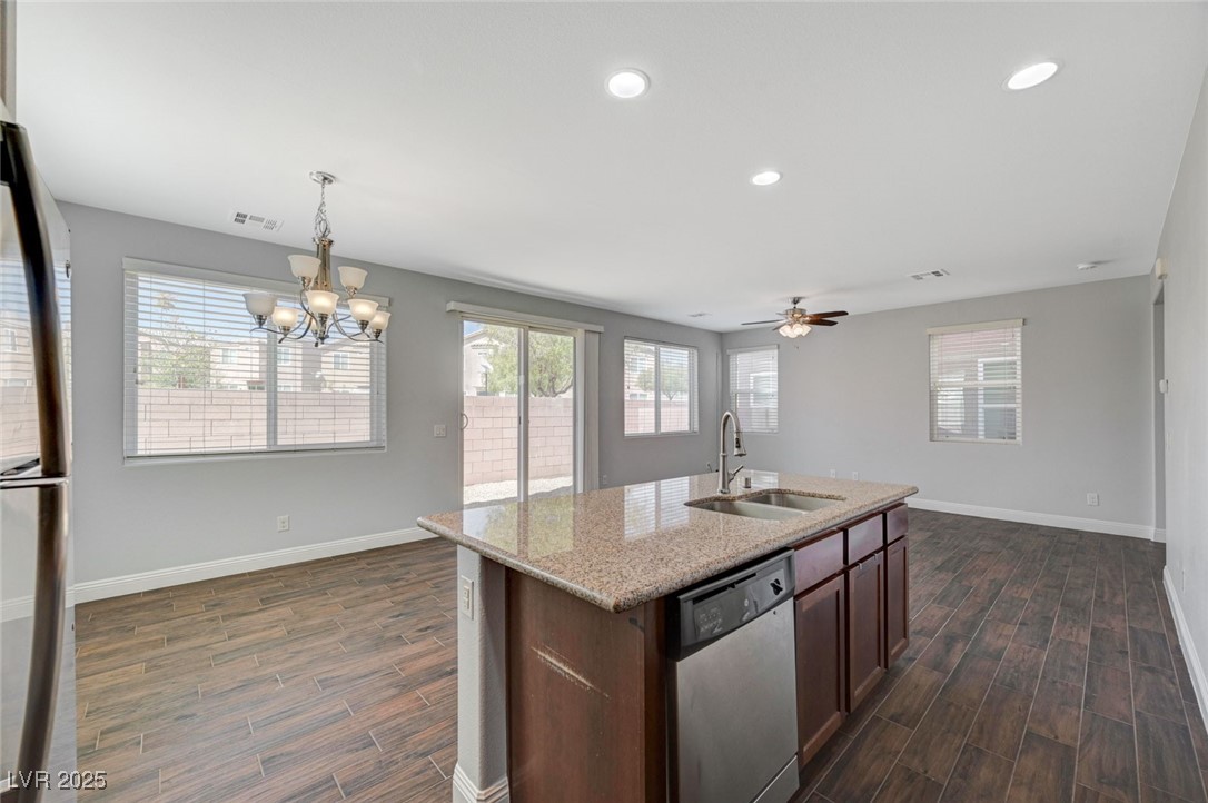 5377 Panaca Spring Street Las Vegas, NV 89122 - Photo 20 of 59 Kitchen featuring light stone countertops, stainless steel appliances, hanging light fixtures, recessed lighting, and dark wood-style floors