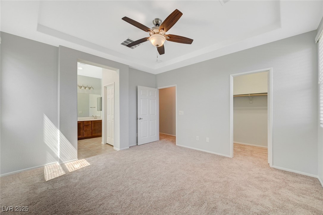 5377 Panaca Spring Street Las Vegas, NV 89122 - Photo 29 of 59 Unfurnished bedroom with a raised ceiling, light colored carpet, and a spacious closet