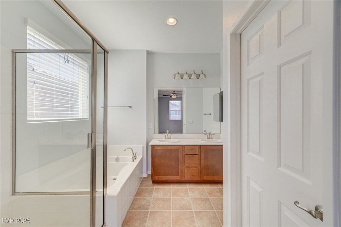 5377 Panaca Spring Street Las Vegas, NV 89122 - Photo 30 of 59 Full bath with a stall shower, double vanity, a bath, light tile patterned flooring, and recessed lighting