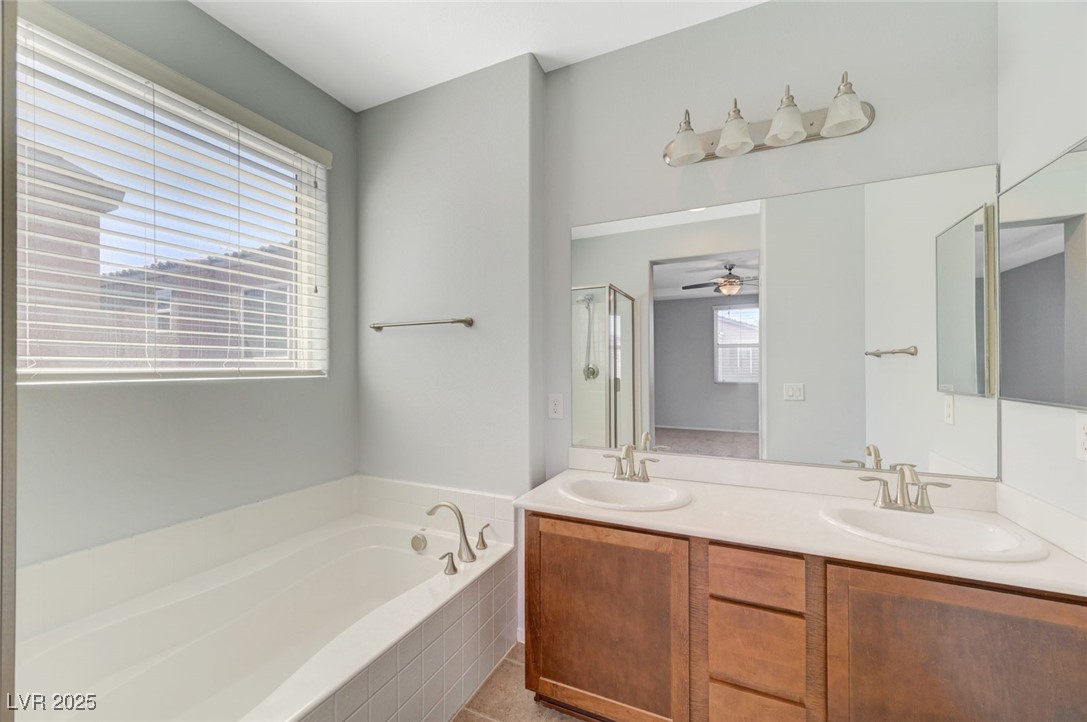 5377 Panaca Spring Street Las Vegas, NV 89122 - Photo 31 of 59 Full bathroom featuring a garden tub, a shower stall, double vanity, and a ceiling fan