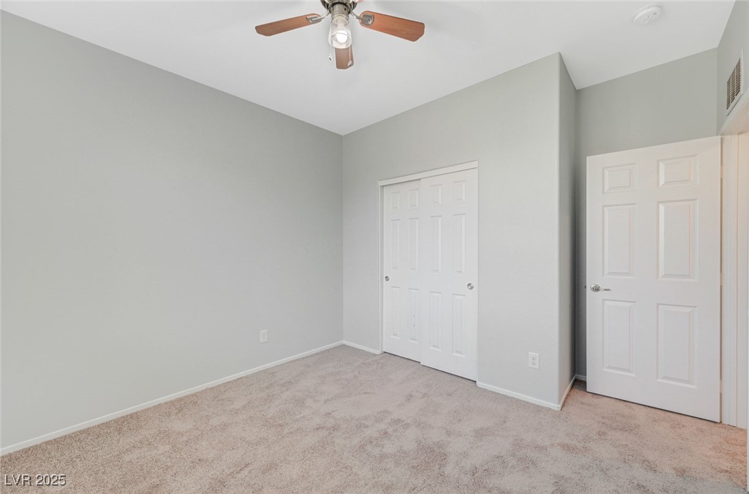 5377 Panaca Spring Street Las Vegas, NV 89122 - Photo 36 of 59 Unfurnished bedroom with light colored carpet, a closet, and a ceiling fan