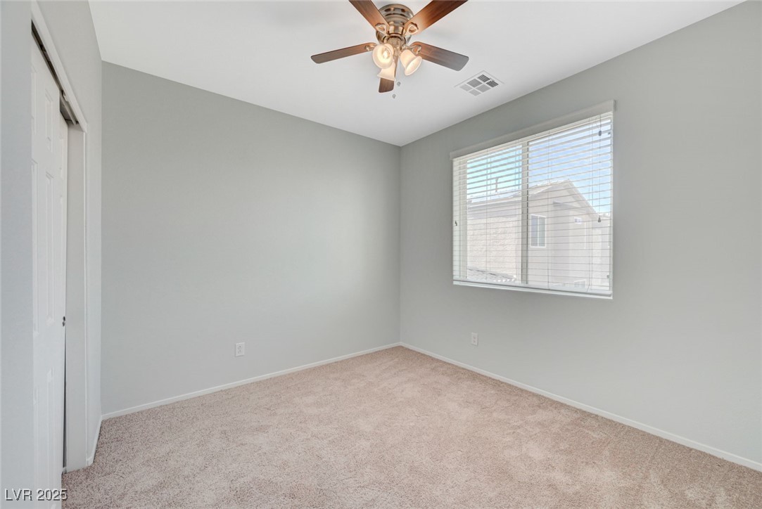 5377 Panaca Spring Street Las Vegas, NV 89122 - Photo 37 of 59 Unfurnished bedroom featuring light colored carpet, a closet, and a ceiling fan