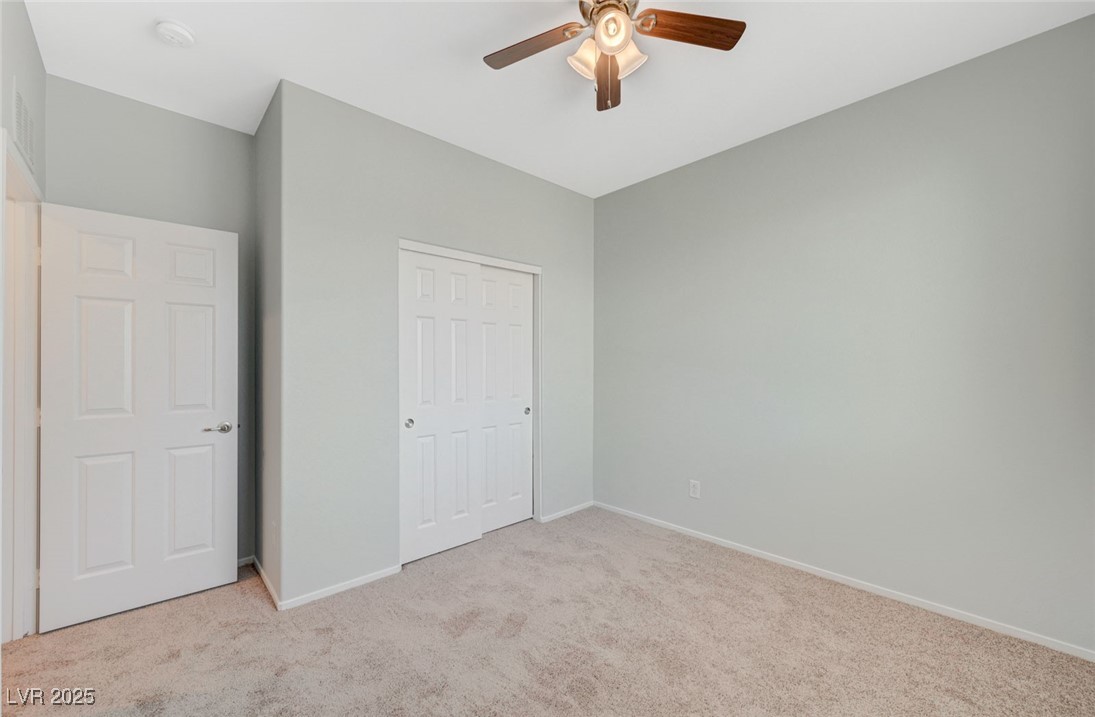5377 Panaca Spring Street Las Vegas, NV 89122 - Photo 38 of 59 Unfurnished bedroom featuring light colored carpet, a closet, and a ceiling fan