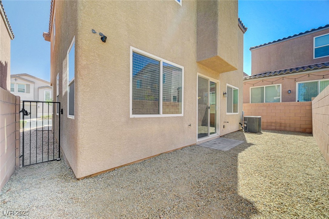 5377 Panaca Spring Street Las Vegas, NV 89122 - Photo 48 of 59 Back of house with stucco siding, a fenced backyard, and a gate
