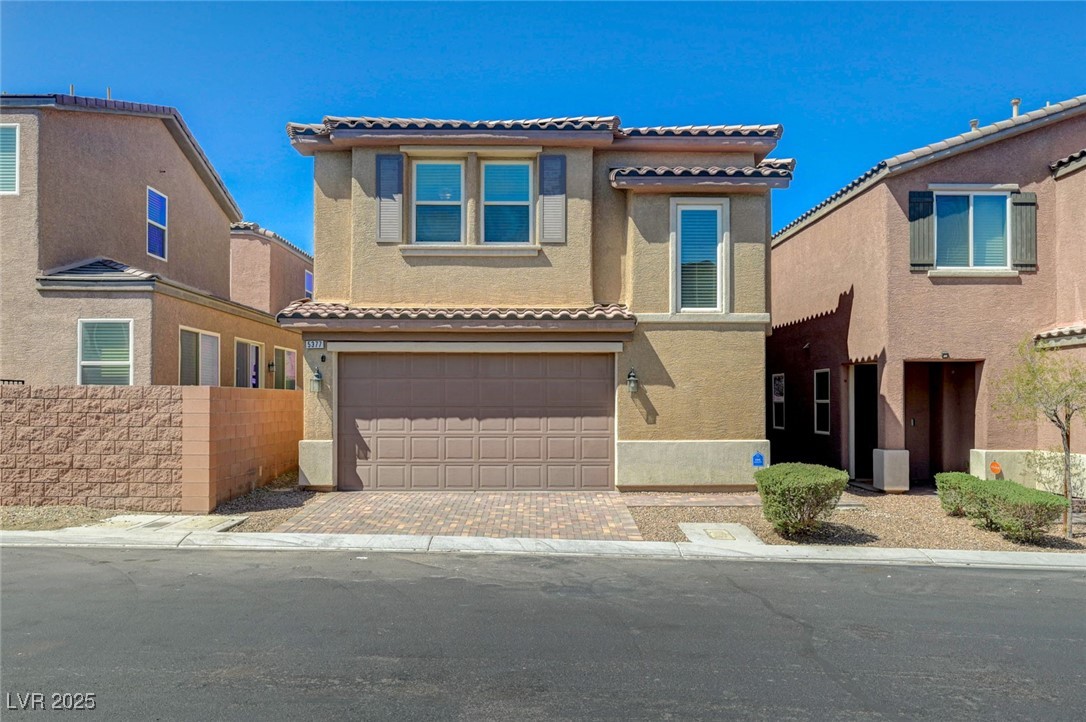 5377 Panaca Spring Street Las Vegas, NV 89122 - Photo 5 of 59 Mediterranean / spanish-style house with stucco siding, a tile roof, an attached garage, and decorative driveway