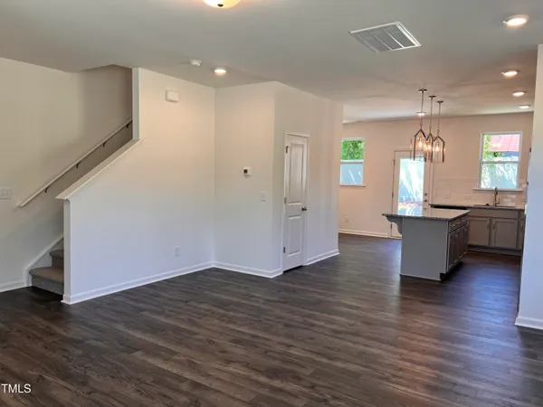 a view of a big room with wooden floor and windows
