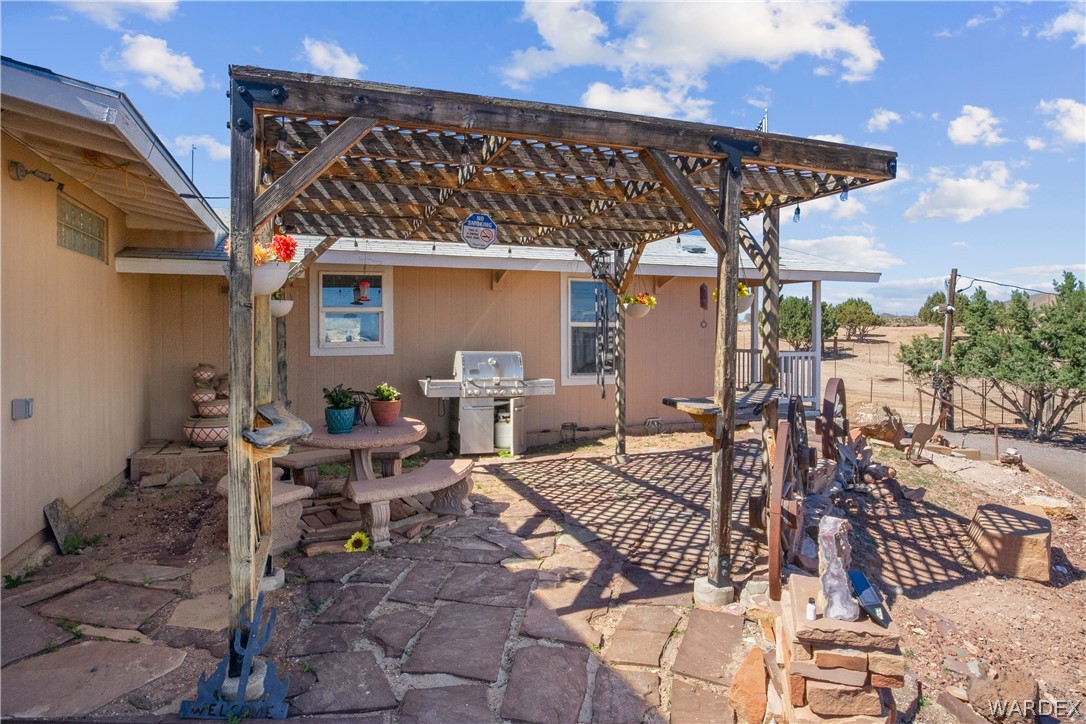 1108 South McCarrel Road Kingman, AZ 86401 - Photo 24 of 65 a view of a patio with table and chairs with wooden floor and fence