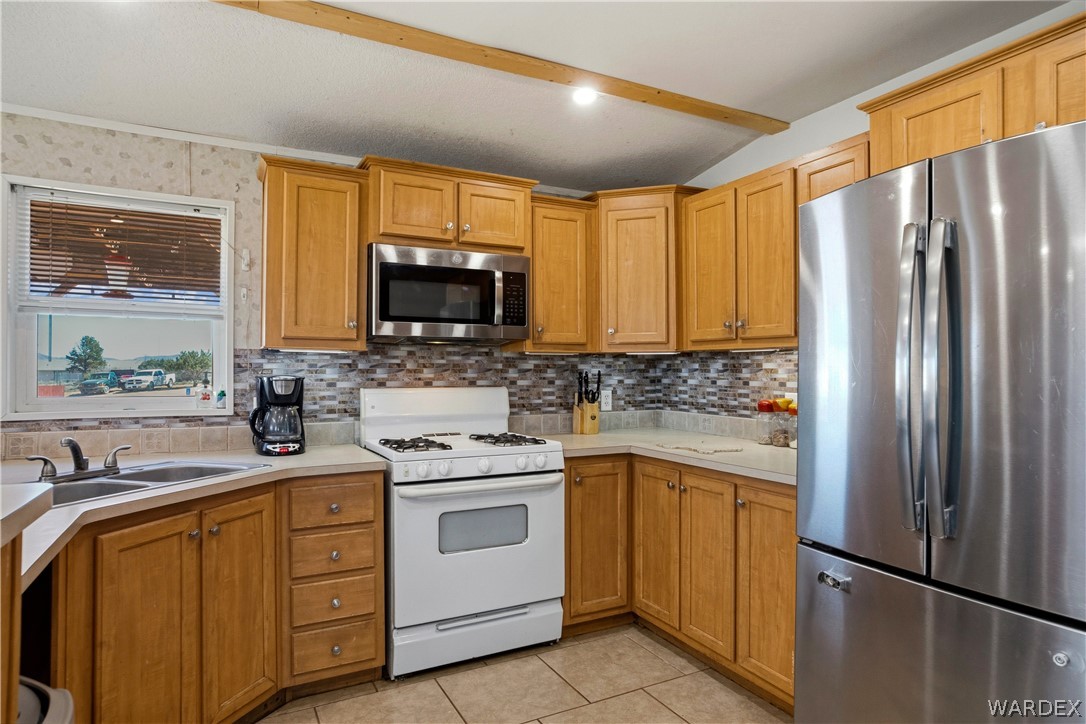 1108 South McCarrel Road Kingman, AZ 86401 - Photo 30 of 65 a kitchen with white cabinets stainless steel appliances and a window