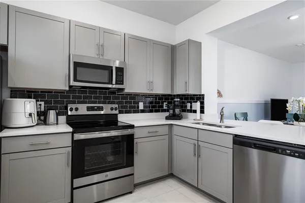 a kitchen with cabinets appliances a sink and a counter top space