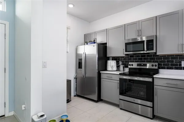 a kitchen with stainless steel appliances granite countertop a stove a refrigerator and a microwave