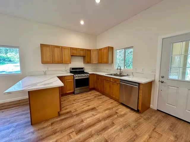 a kitchen with stainless steel appliances granite countertop a stove a sink dishwasher and a refrigerator