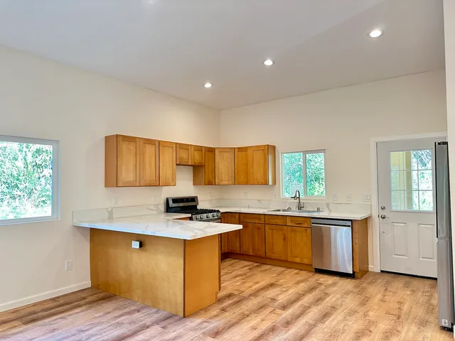 a kitchen with stainless steel appliances granite countertop a sink stove and cabinets