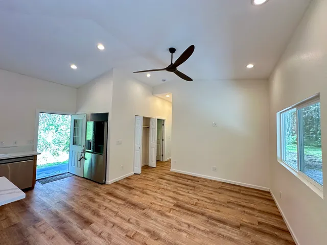 a view of empty room with wooden floor and window
