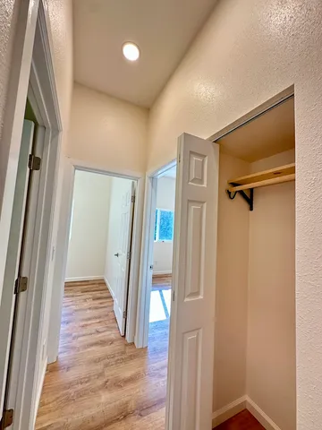 a view of a hallway with wooden floor and entryway