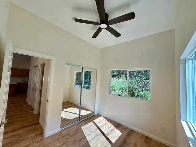 a view of entryway and bedroom with wooden floor