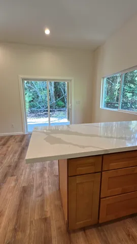 an empty room with wooden floor and a sink