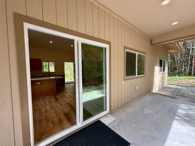 a view of a hallway with wooden floor and a living room