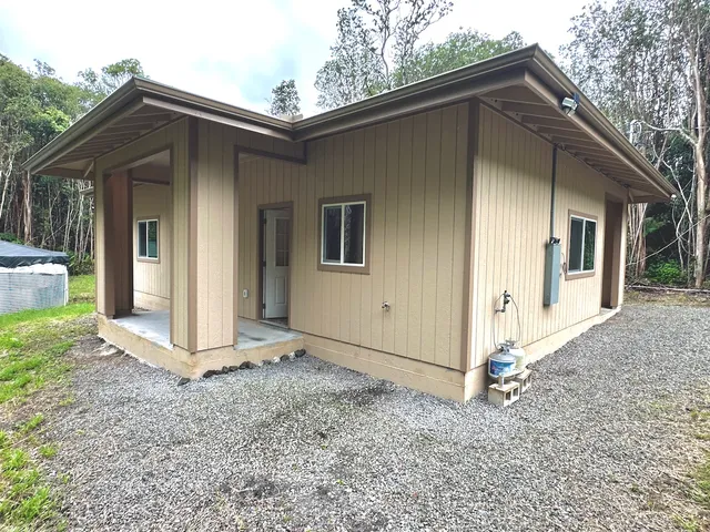 a view of wooden house with a yard