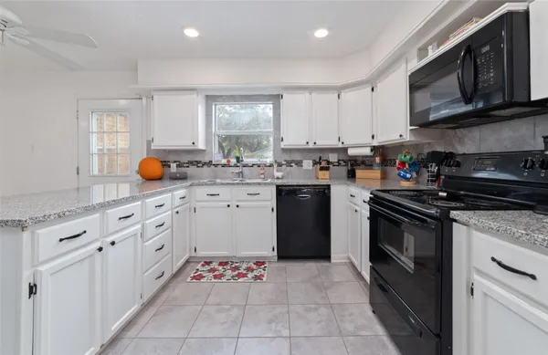 a kitchen with kitchen island granite countertop a stove sink and cabinets