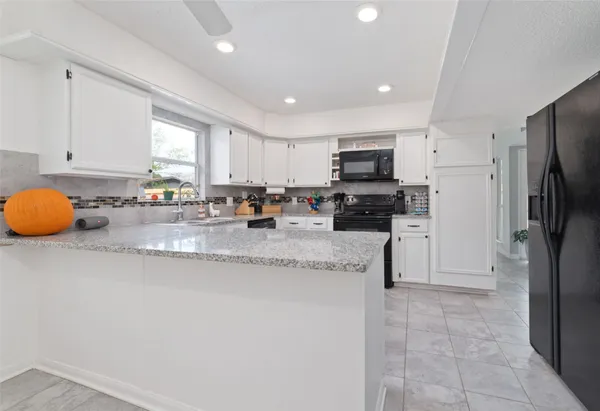 a kitchen with stainless steel appliances granite countertop a stove a sink dishwasher and a microwave oven with cabinets