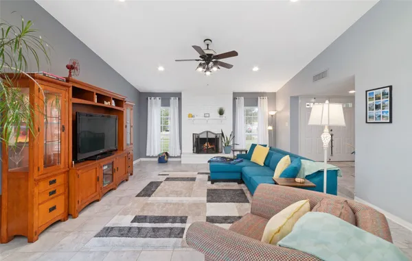 a living room with furniture a flat screen tv and a table