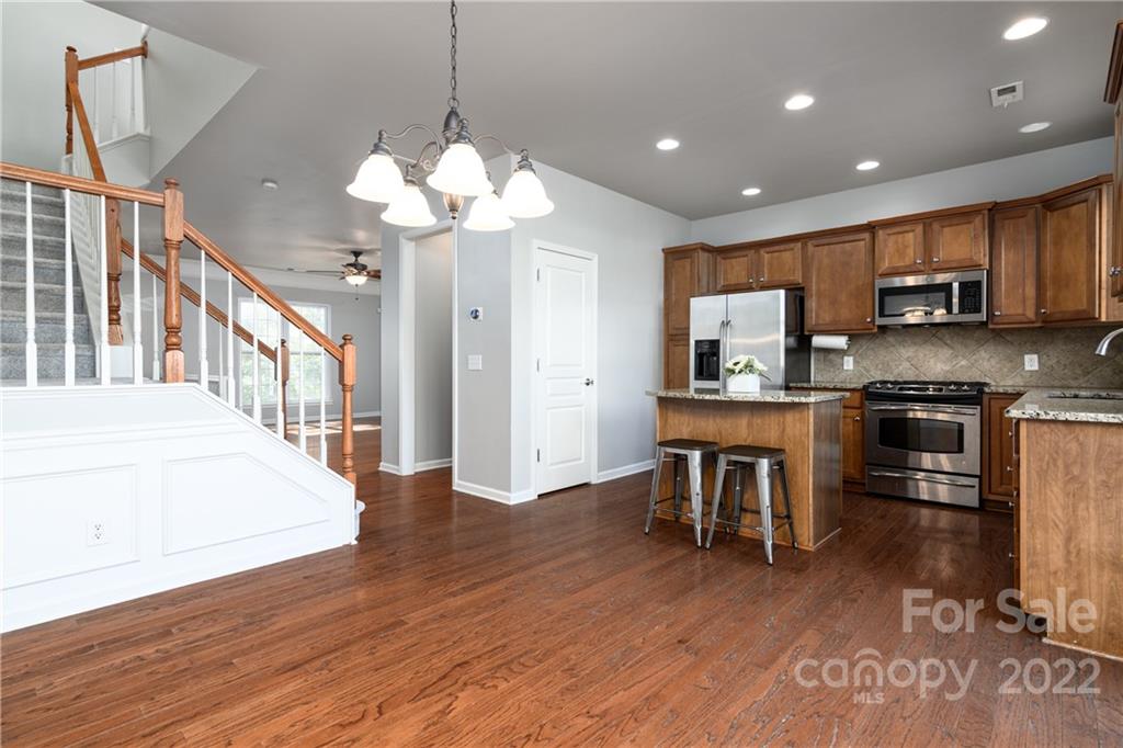 669 6th Baxter Crossing Fort Mill, SC 29708 - Photo 11 of 39 a open kitchen with stainless steel appliances granite countertop a refrigerator a stove top oven a sink dishwasher and white cabinets with wooden floor