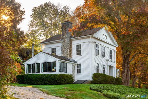 a front view of a house with a yard and trees