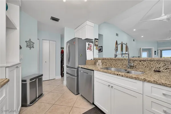 a kitchen with granite countertop white cabinets and appliances