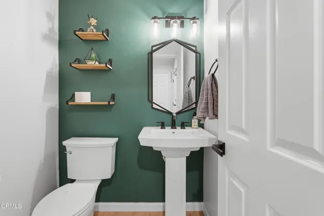 a bathroom with a toilet sink and mirror