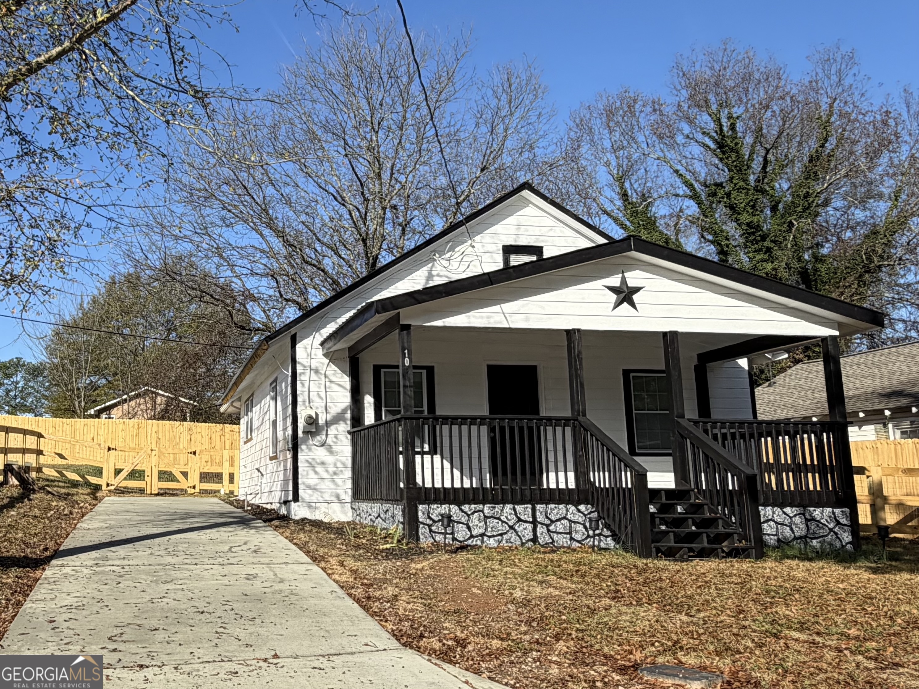 a view of a house with wooden fence next to a road