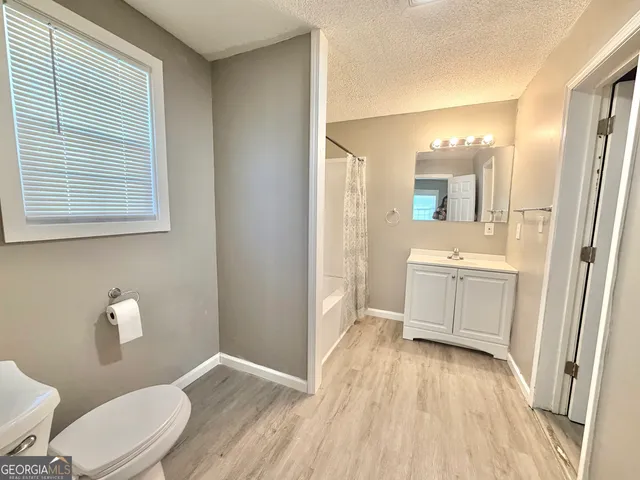 a bathroom with a sink a toilet a mirror and window