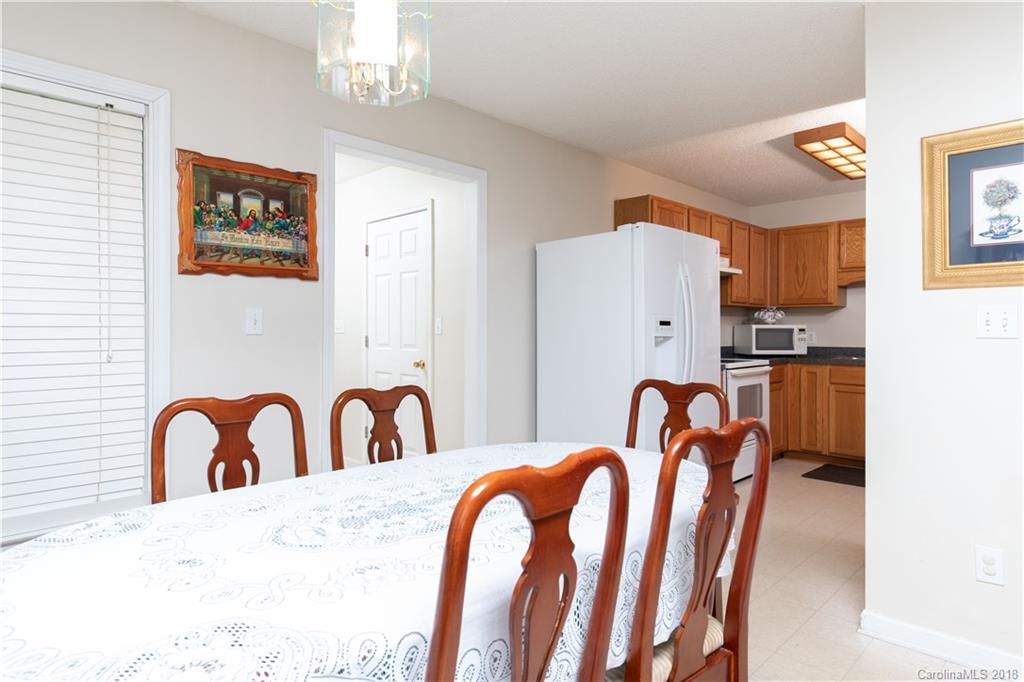 1007 Field Swallow Way, Unit 69 Clover, SC 29710 - Photo 5 of 18 a kitchen with stainless steel appliances granite countertop a dining table chairs and a refrigerator