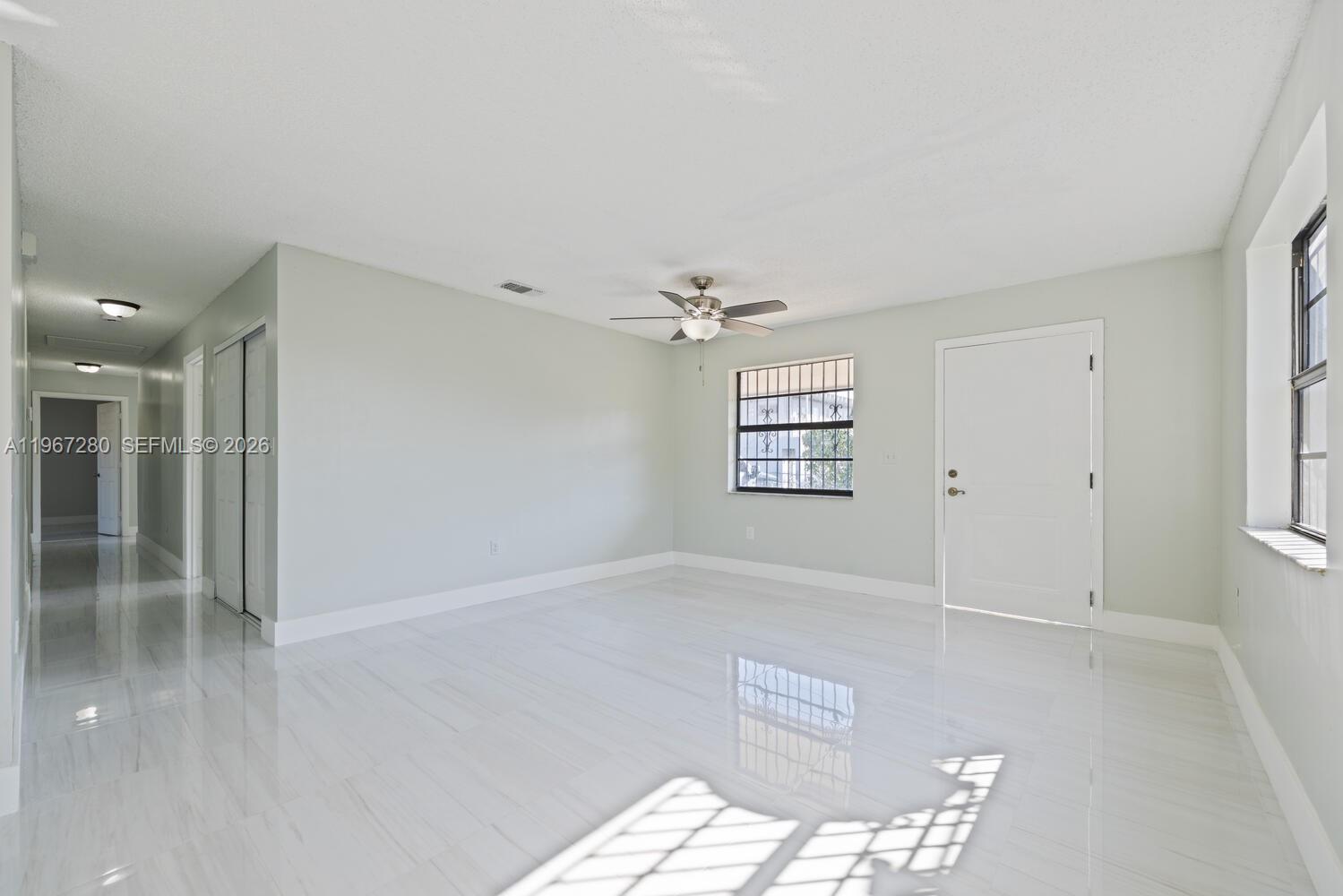 522 Southwest 3rd Avenue Homestead, FL 33030 - Photo 6 of 20 an empty room with windows and ceiling fan