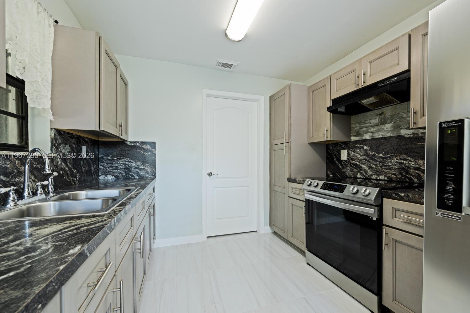 522 Southwest 3rd Avenue Homestead, FL 33030 - Photo 9 of 20 a kitchen with stainless steel appliances granite countertop a sink stove and microwave
