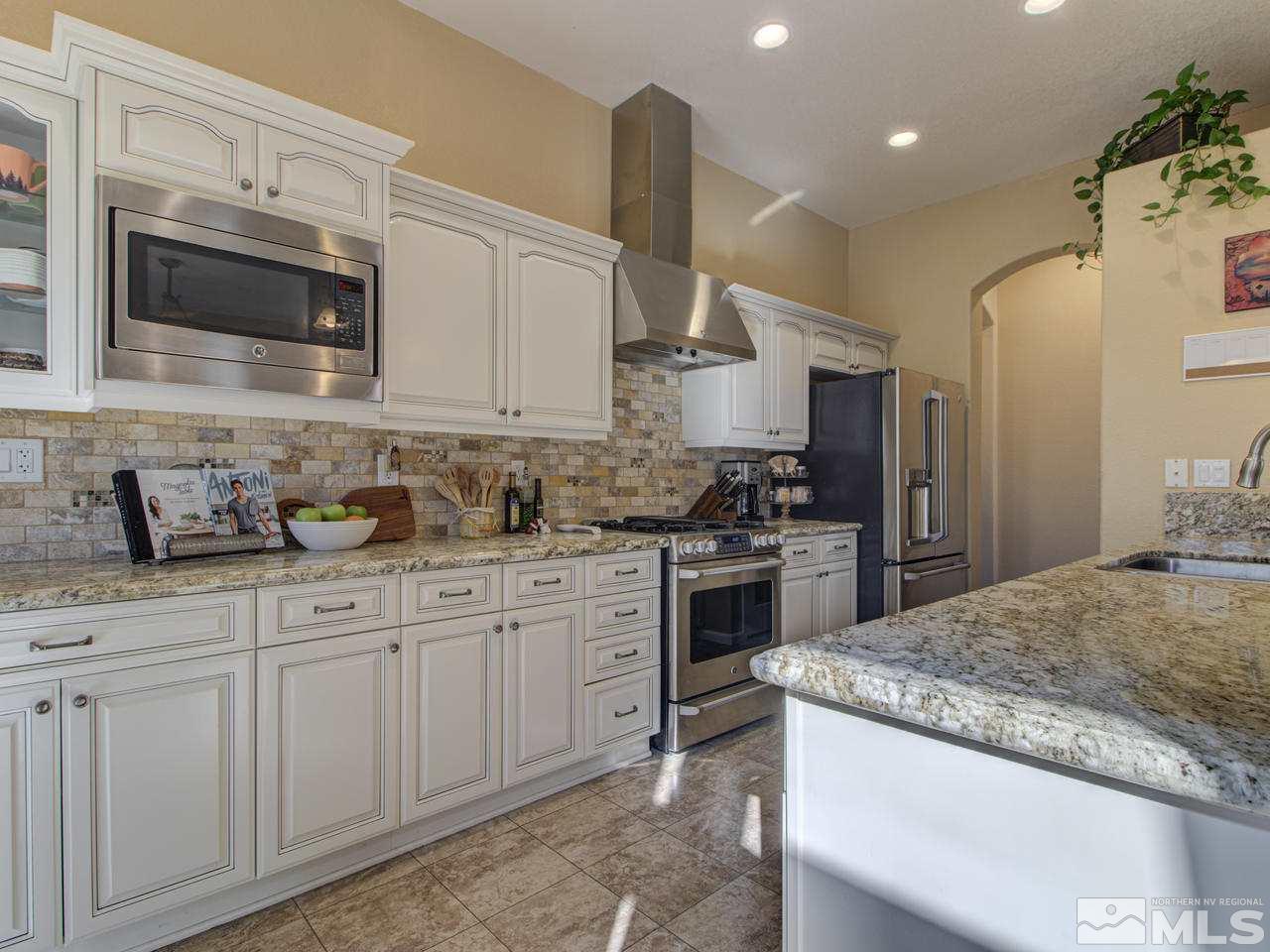 1870 Beringer Way Reno, NV 89521 - Photo 4 of 25 a kitchen with granite countertop white cabinets and stainless steel appliances