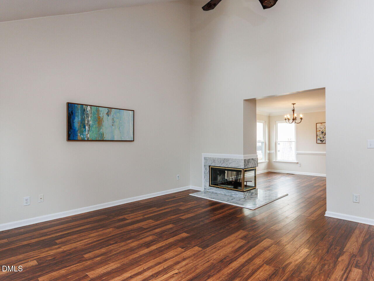 Living area with soaring ceilings, large dormers. A cozy dual-sided fireplace connects the family and dining areas.